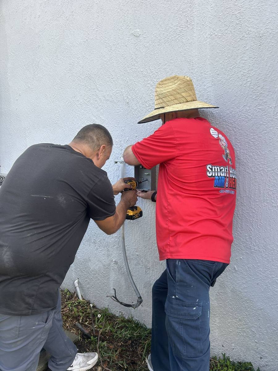 Smart Home Air and Heat technicians working together on an HVAC installation in East Orlando
